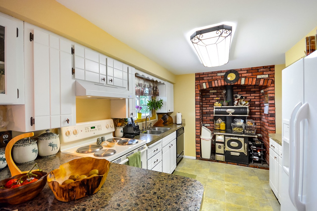 Moderne keuken met zichtbare bakstenen en groen planten.